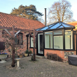 Black conservatory in a courtyard by WDC Anglia
