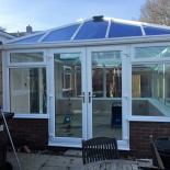White conservatory with French doors and blue tinted roof by WDC Anglia
