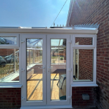 White conservatory with French doors by WDC Anglia